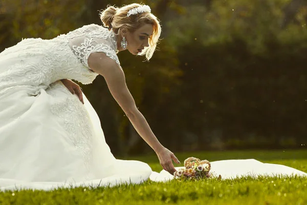 Istanbul wedding photography: Bride with puffy skirt picking flowers from the ground