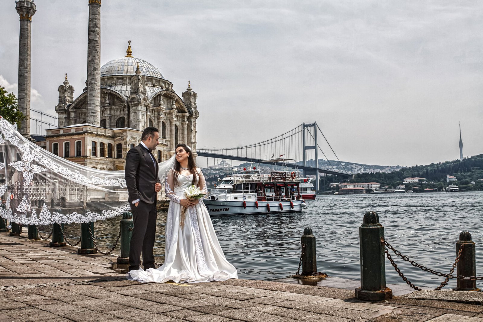 Istanbul wedding photography of stylish bride and groom with Ortakoy Mosque in the background