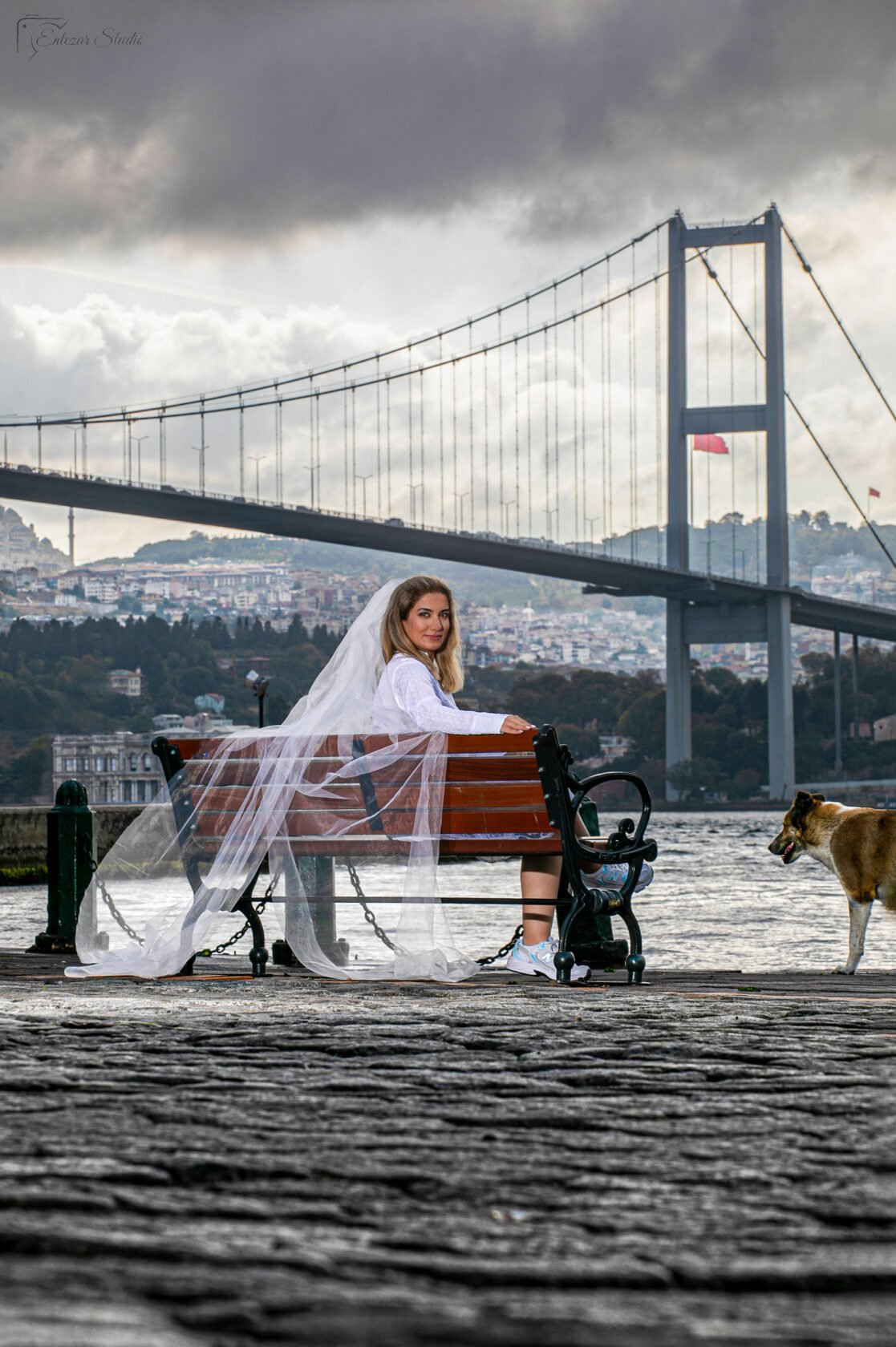 Wedding photography at sunrise in Istanbul with a long bridal veil and a dog in the background by Entezar Studio