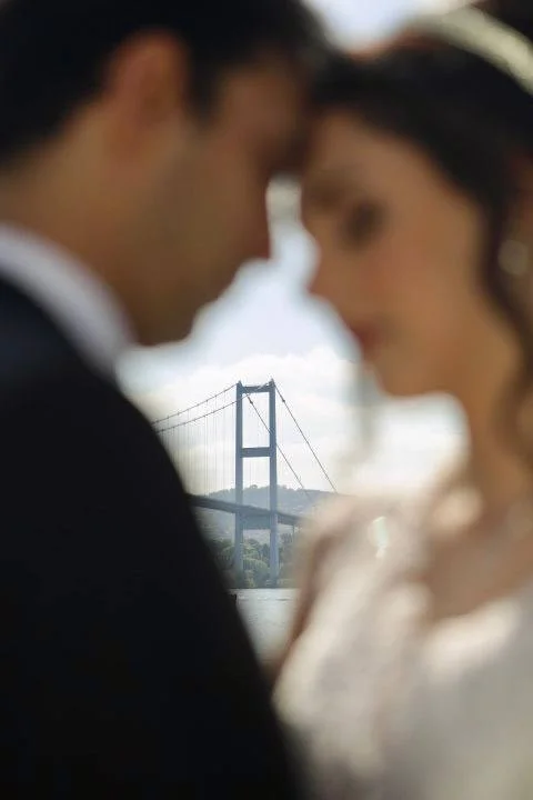 Wedding photography on Ortakoy Street Istanbul framed by the Bosphorus Bridge by Entezar Studio